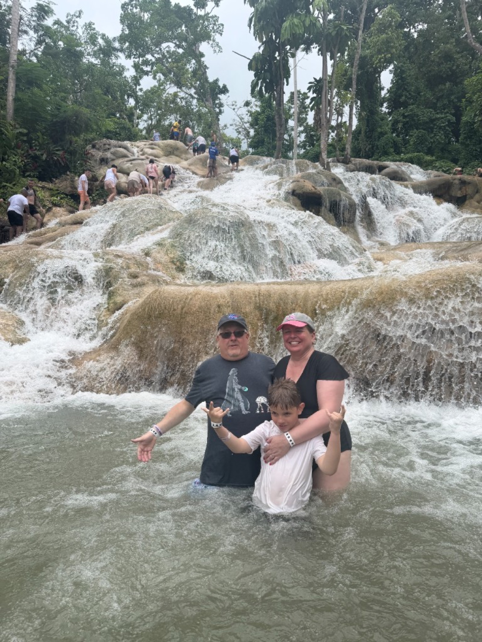 A family standing together in the water at Dunn’s River Falls in Jamaica