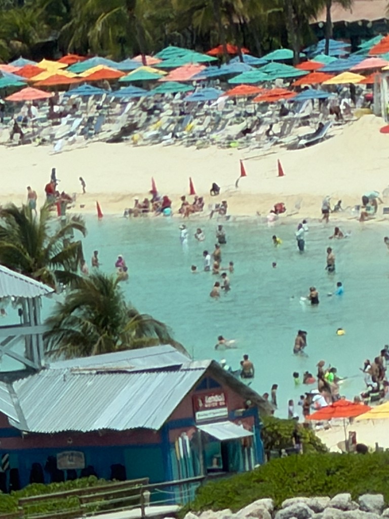 Busy family beach lagoon and umbrellas at Castaway Cay