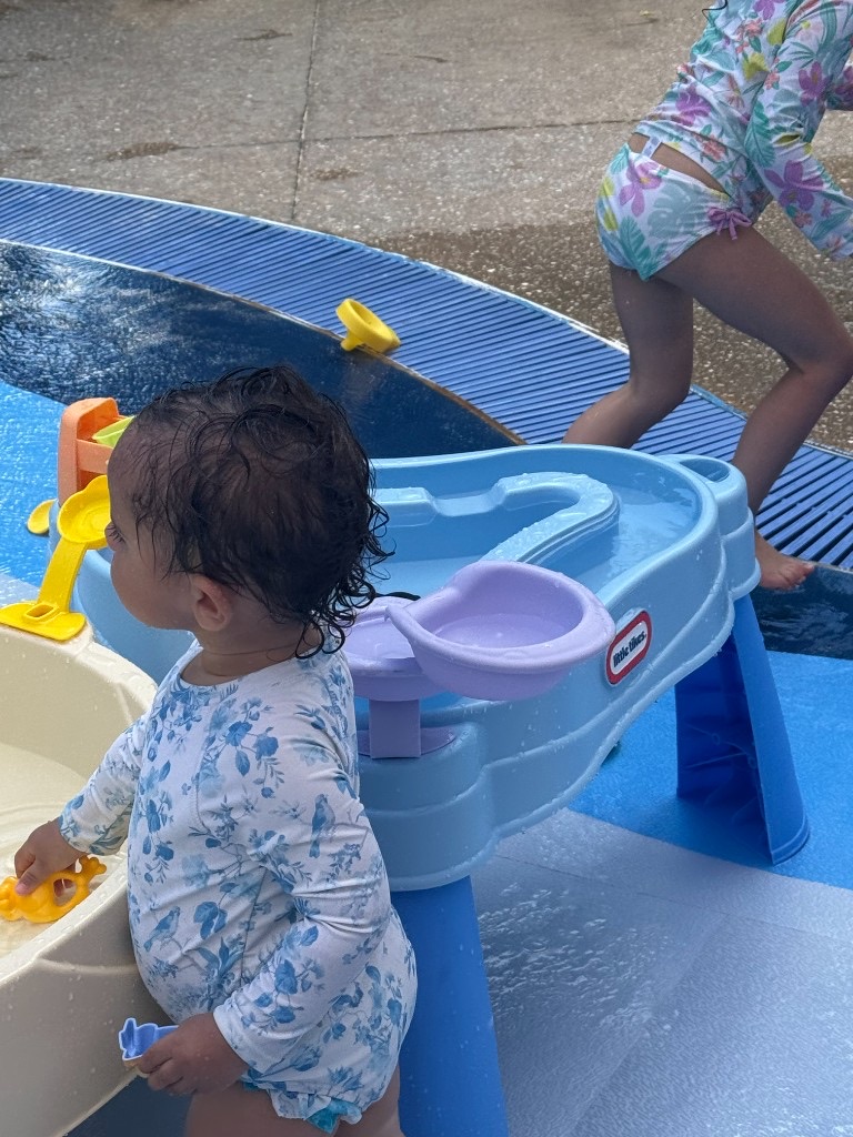 Toddler playing at a splash pad water table on a Disney cruise