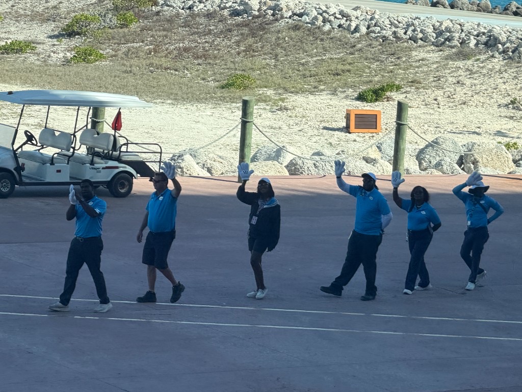 Castaway Cay crew waving goodbye with Mickey Mouse gloves